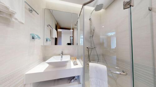 a white bathroom with a sink and a shower at vinhomes metropolis 3 phòng ngủ in Hanoi