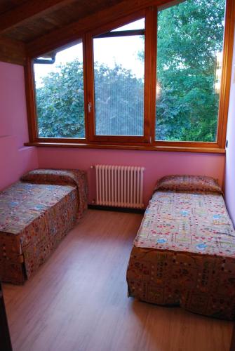 a room with two beds and a large window at Agriturismo Il Frutto Permesso in Bibiana