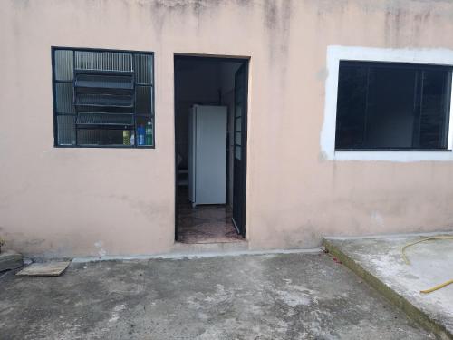 otwarte drzwi budynku obok okna w obiekcie Casa de temporada em São Tomé das Letras w mieście São Thomé das Letras