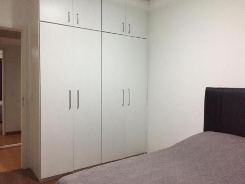 1 dormitorio con armarios blancos y 1 cama en Apartamento Praia Orla Barra da Tijuca, en Río de Janeiro
