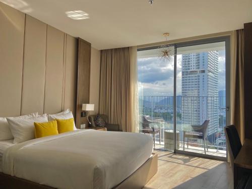 a hotel room with a large bed and a balcony at Panorama Nha Trang in Nha Trang