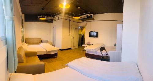 a hospital room with two beds and a couch at EasyInn Hotel & Hostel in Tainan