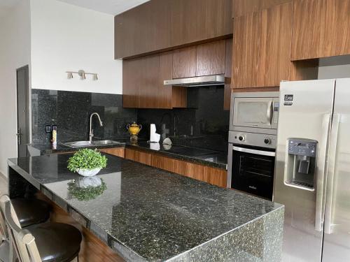 a kitchen with a granite counter top and wooden cabinets at Quinta BarLó in General Zuazua