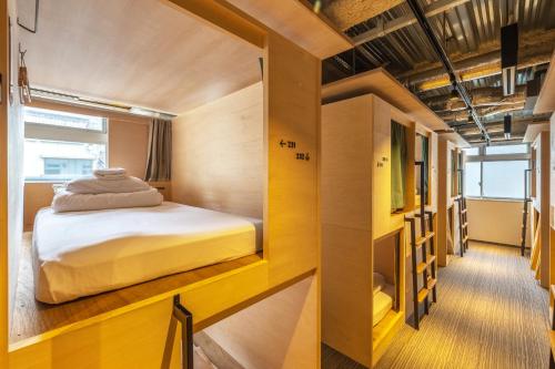 ein kleines Schlafzimmer mit einem Bett in der Mitte in der Unterkunft UNPLAN Kagurazaka in Tokio