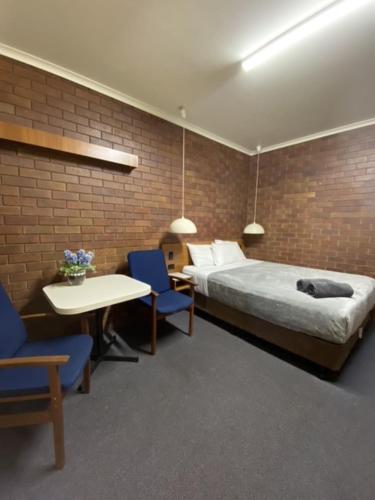 Un pat sau paturi într-o cameră la Golden West Motor Inn