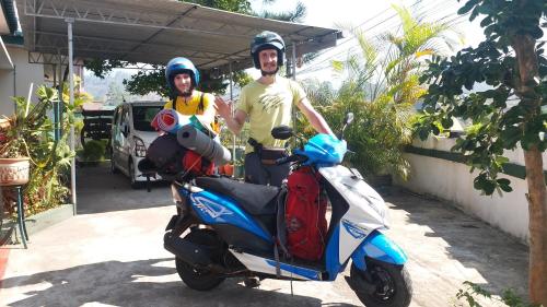 two men wearing helmets standing next to a scooter at KPL Holiday Homes in Hatton