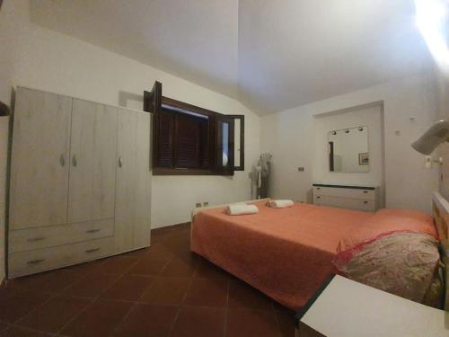 1 dormitorio con 1 cama grande y espejo en Villa Capodorso, Palau Porto Pollo, en Palau