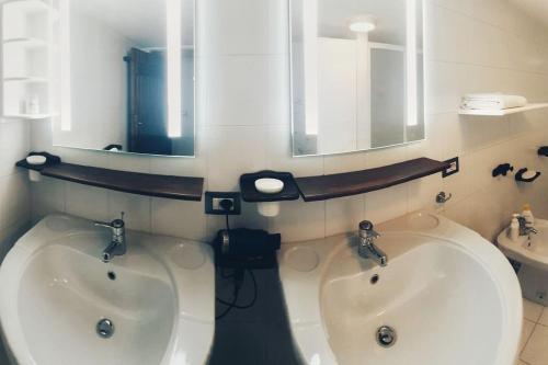 y baño con espejo y 2 lavabos blancos. en Villa Capodorso, Palau Porto Pollo, en Palau