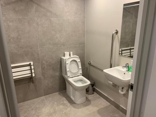 uma casa de banho com um WC e um lavatório em Garden Hostel em Auckland