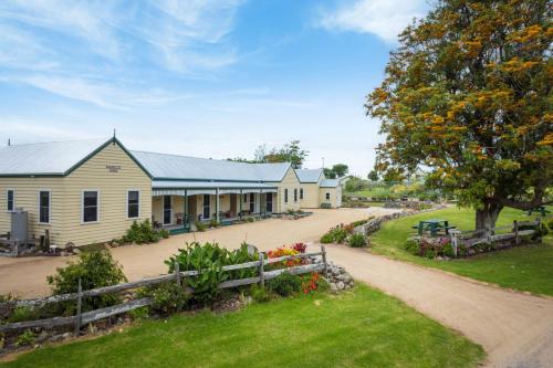 a house with a fence and a dirt road at Henkley Cottage 4 Daniel in Central Tilba