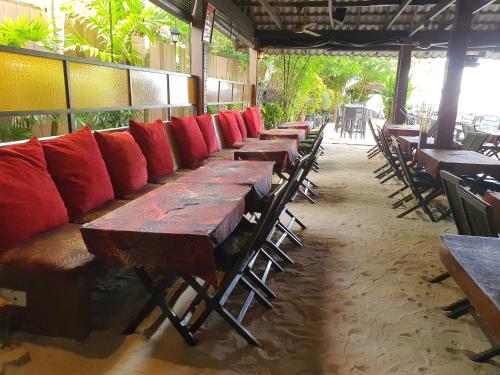 a row of wooden tables and chairs in a restaurant at Ombak Dive Resort Perhentian Island in Perhentian Island