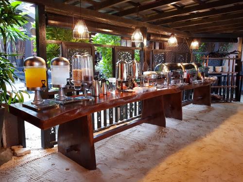 a bar with a long wooden table with many bottles at Ombak Dive Resort Perhentian Island in Perhentian Islands