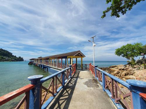 a pier with a building on the water at Ombak Dive Resort Perhentian Island in Perhentian Island