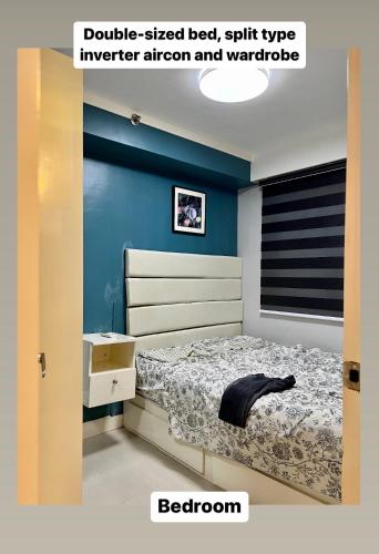 a bedroom with a bed and a blue wall at Staycation at The Avenue Residences by Melo in Manila