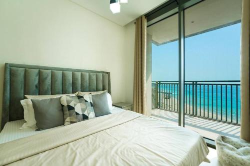 a bedroom with a large bed and a balcony at Blu Water Luxury Tow Bedroom Apartment - Marina in Dubai