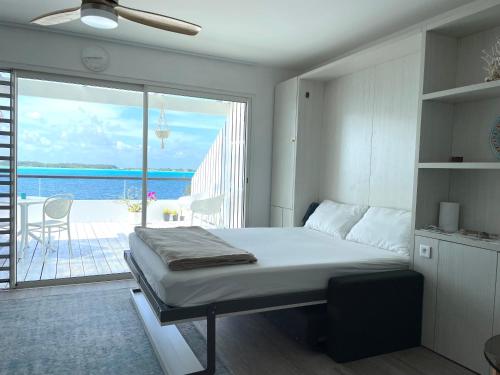 a bedroom with a bed and a view of the ocean at Studio Deluxe in Bora Bora