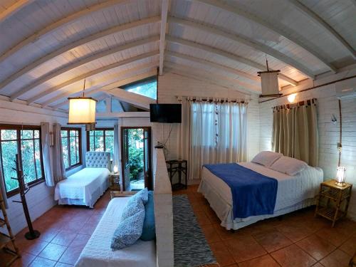 1 dormitorio con 1 cama y 1 sofá en una habitación en Condomínio Aldeia dos Anjosdo Rosa, en Praia do Rosa