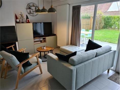 a living room with a couch and a tv at Groendijk 105 in Koksijde