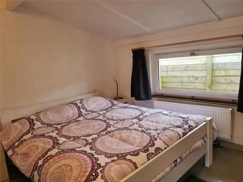 łóżko w pokoju z oknem w obiekcie Groendijk 105 w mieście Koksijde