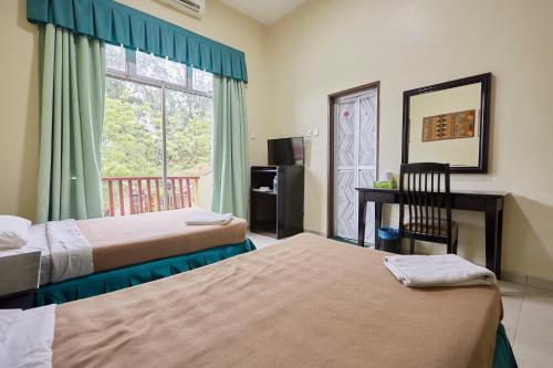 ein Hotelzimmer mit 2 Betten und einem Fenster in der Unterkunft Terengganu Equestrian Resort in Kuala Terengganu