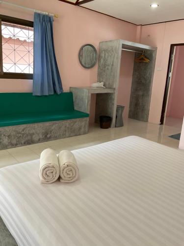 a bedroom with a bed with two towels on it at Island Spa Resort in Koh Tao