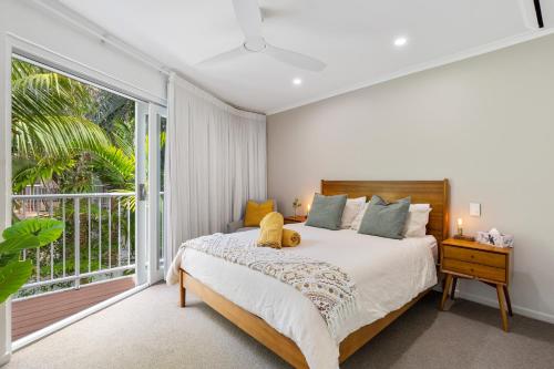 a bedroom with a bed and a large window at Little cove gem - walking distance to the most famous Noosa beach! in Noosa Heads