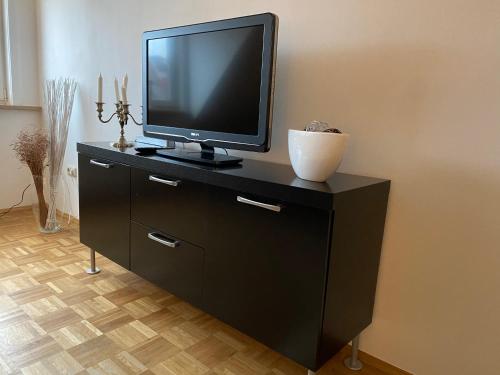 uma televisão em cima de uma cómoda preta em Findorff em Bremen