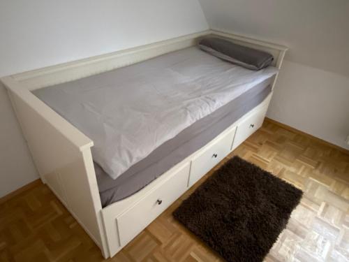 Cama blanca en habitación con alfombra en Findorff en Bremen