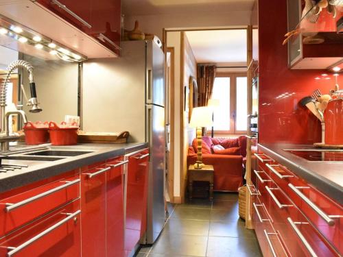 kuchnia z czerwonymi szafkami i czerwoną kanapą w obiekcie Appartement Méribel, 6 pièces, 12 personnes - FR-1-180-338 w mieście Les Allues