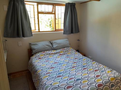 a bedroom with a bed in a room with a window at Dorset Cottage in Cape Town