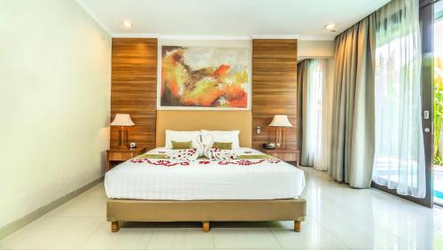 a bedroom with a bed and a painting on the wall at Sotis Villas Canggu in Canggu