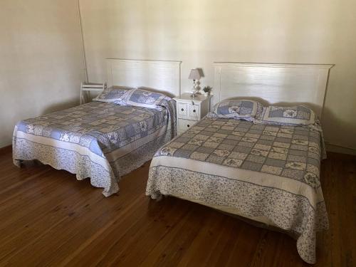 two beds in a room with wooden floors at Estancia Santa Margarita 1873 in Junín