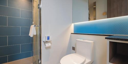 a bathroom with a toilet and a blue tiled wall at Holiday Inn Express Taiyuan High Tech Zone by IHG in Taiyuan