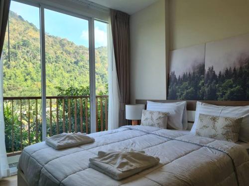 1 dormitorio con 1 cama grande y ventana grande en Baan Khaoyai cozy en Ban Tha Maprang