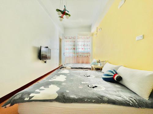 a bedroom with a large bed in a room at Happy Together Guesthouse in Taitung City