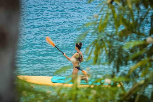 a woman on a paddle board in the water at Maayo San Remigio in San Remigio