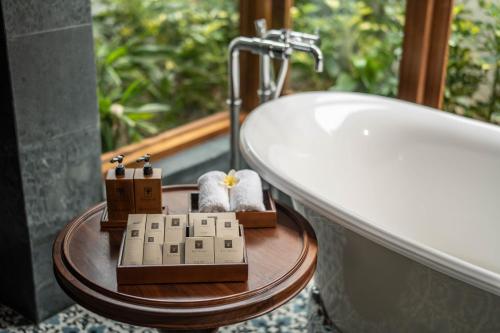 a bathroom with a bath tub and a sink at The Anam Mui Ne in Mui Ne