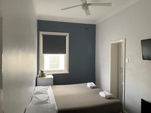 Schlafzimmer mit einem Bett und einem Deckenventilator in der Unterkunft Union Club Hotel in Colac