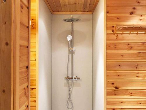 a shower in a bathroom with wooden walls at Four-Bedroom Holiday home in Norheimsund in Norheimsund