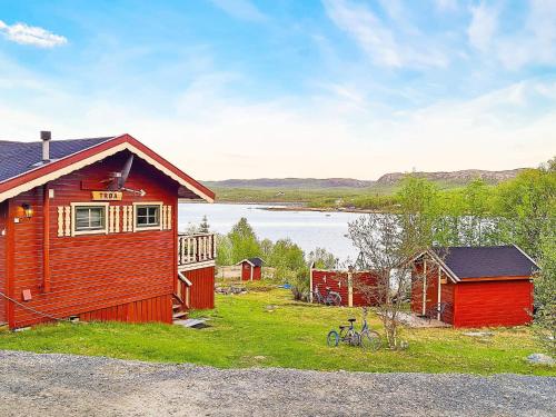 a cabin with a bike parked next to a lake at 7 person holiday home in JARFJORD in Karpbukt