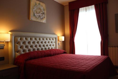 a bedroom with a red bed and a window at Hotel Adler in Menaggio