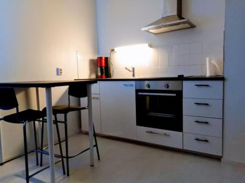 a kitchen with a counter and a table and chairs at Rivitalon pieni päätykaksio - 37 m2 in Jämsä