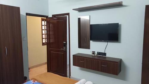 a living room with a tv on a wall at Tru Comfort in Puducherry