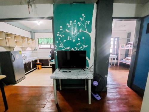 a kitchen with a table with a television on it at Convenient 3-Bedroom Apartment in Baguio