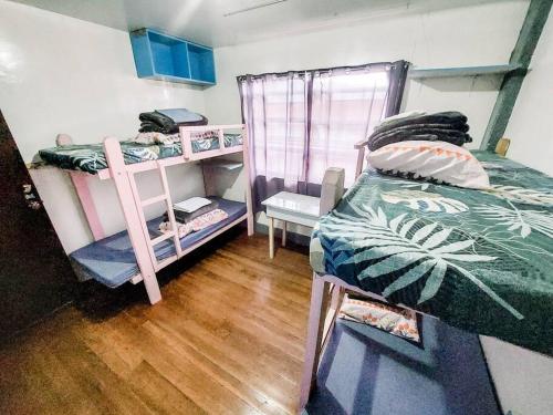 a bedroom with two bunk beds and a wooden floor at Convenient 3-Bedroom Apartment in Baguio