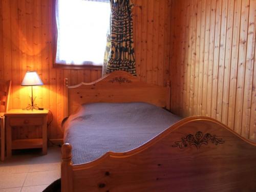 ein Schlafzimmer mit einem Holzbett und einem Fenster in der Unterkunft Gîte Mesples, 3 pièces, 4 personnes - FR-1-489-402 in Mesples