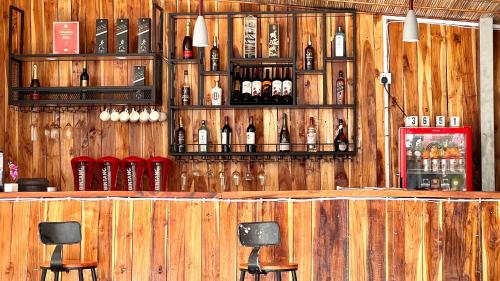 M Y hotel في ديلي: بار به زجاجات من النبيذ على جدار خشبي