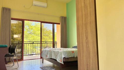ein Schlafzimmer mit Bett und Balkon in der Unterkunft M Y hotel in Dili