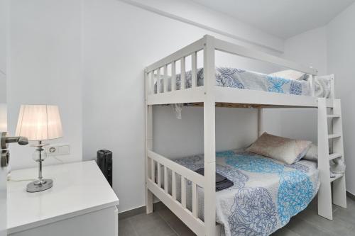 - une chambre avec des lits superposés, un bureau et une lampe dans l'établissement Verano Azul, à Nerja