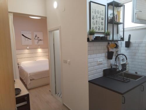a kitchen with a sink and a bed in a room at Apartment Vespa & Jacuzzi in Split